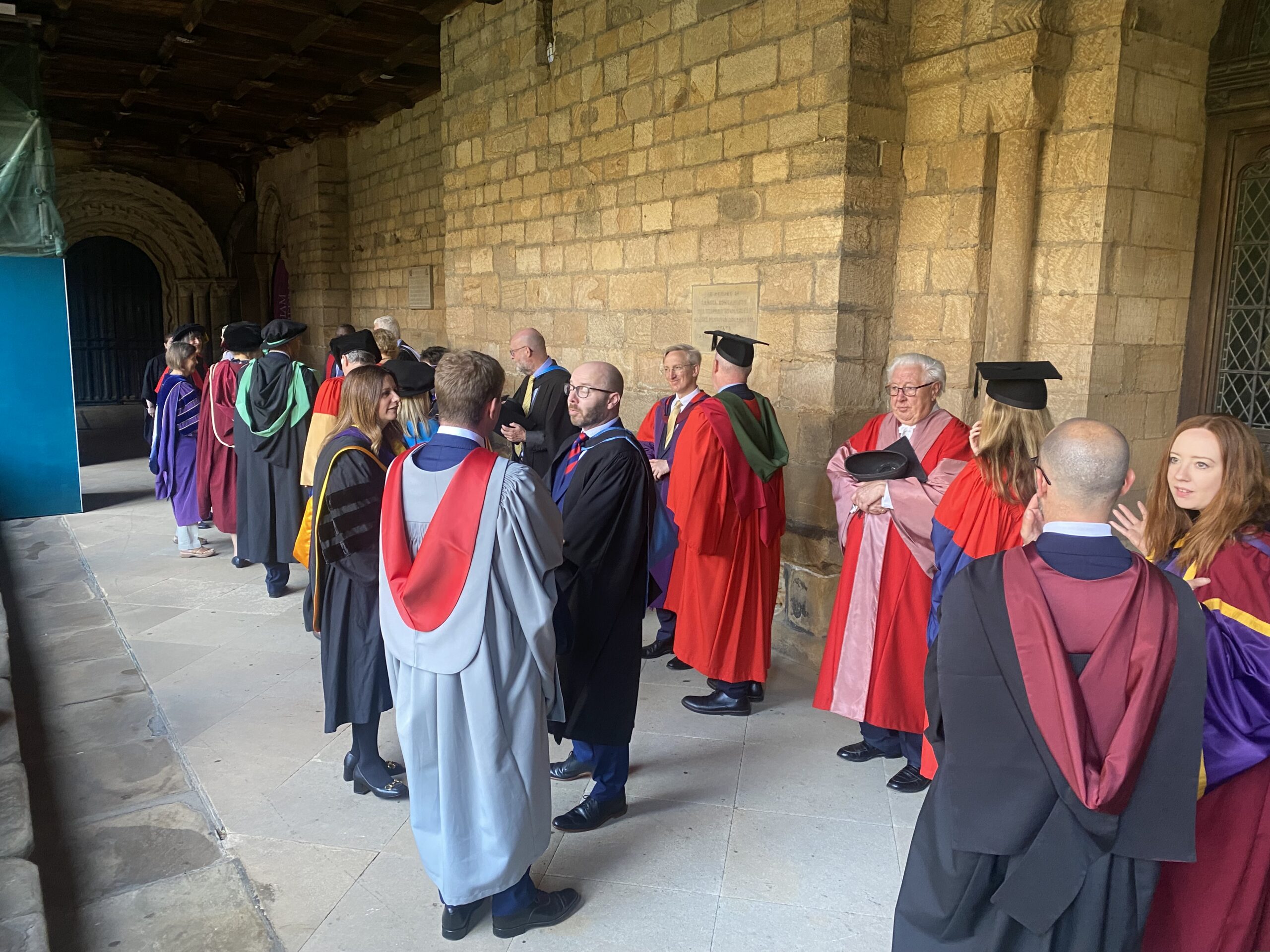 A group in academic dress in a cloister